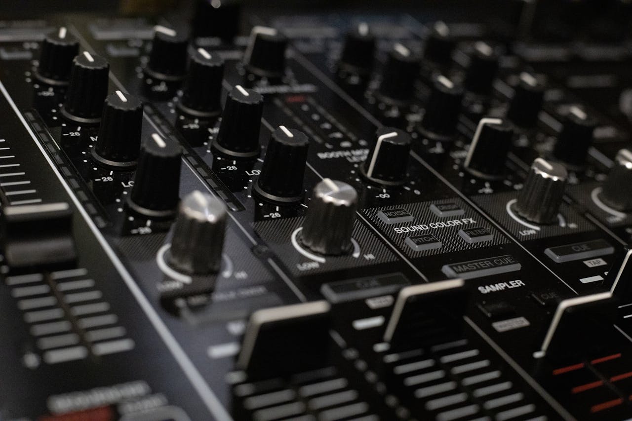 about-us Detailed close-up of a professional audio mixer console with various knobs and controls.